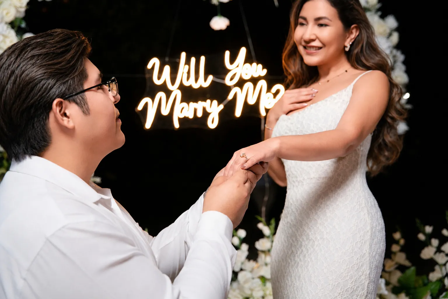 Henry toma la mano de Madeleine frente al letrero «Will you marry me?»